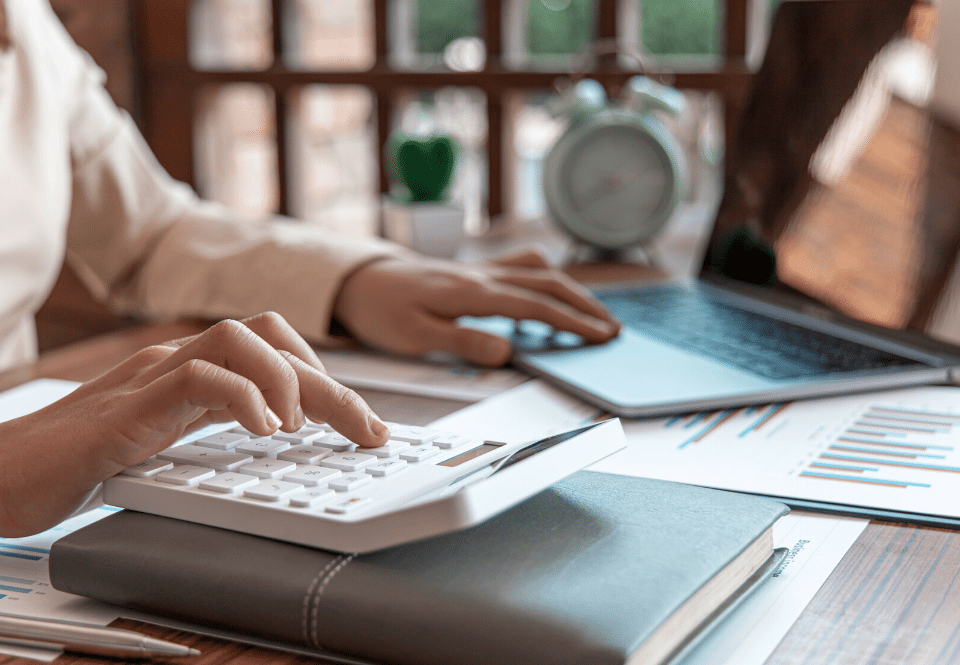 hands typing at a calculator