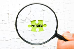 Magnifying glass on problem puzzle piece