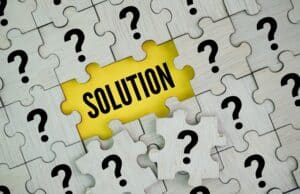 Wooden puzzle pieces with question mark and solution in the middle